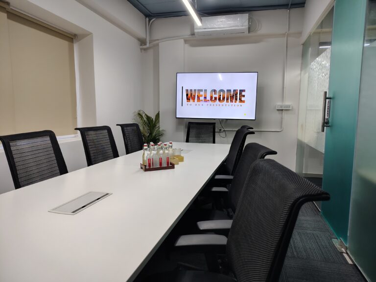 A modern meeting room at Elite Co-Works in BTM Layout, Bangalore, equipped with a wall-mounted big monitor, air conditioning, and ergonomic seating, designed to support productive team discussions and presentations in a premium coworking space environment.